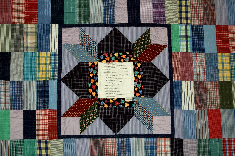 Center of bereavement quilt made of ties and a print of her favorite poem